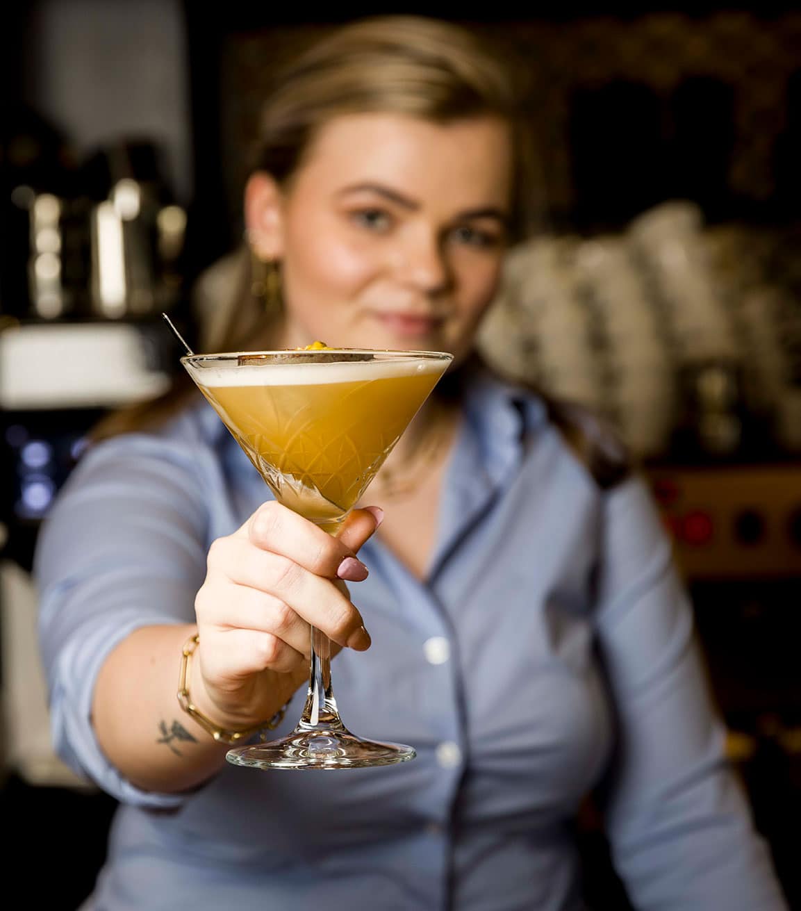a woman holding a glass of drink